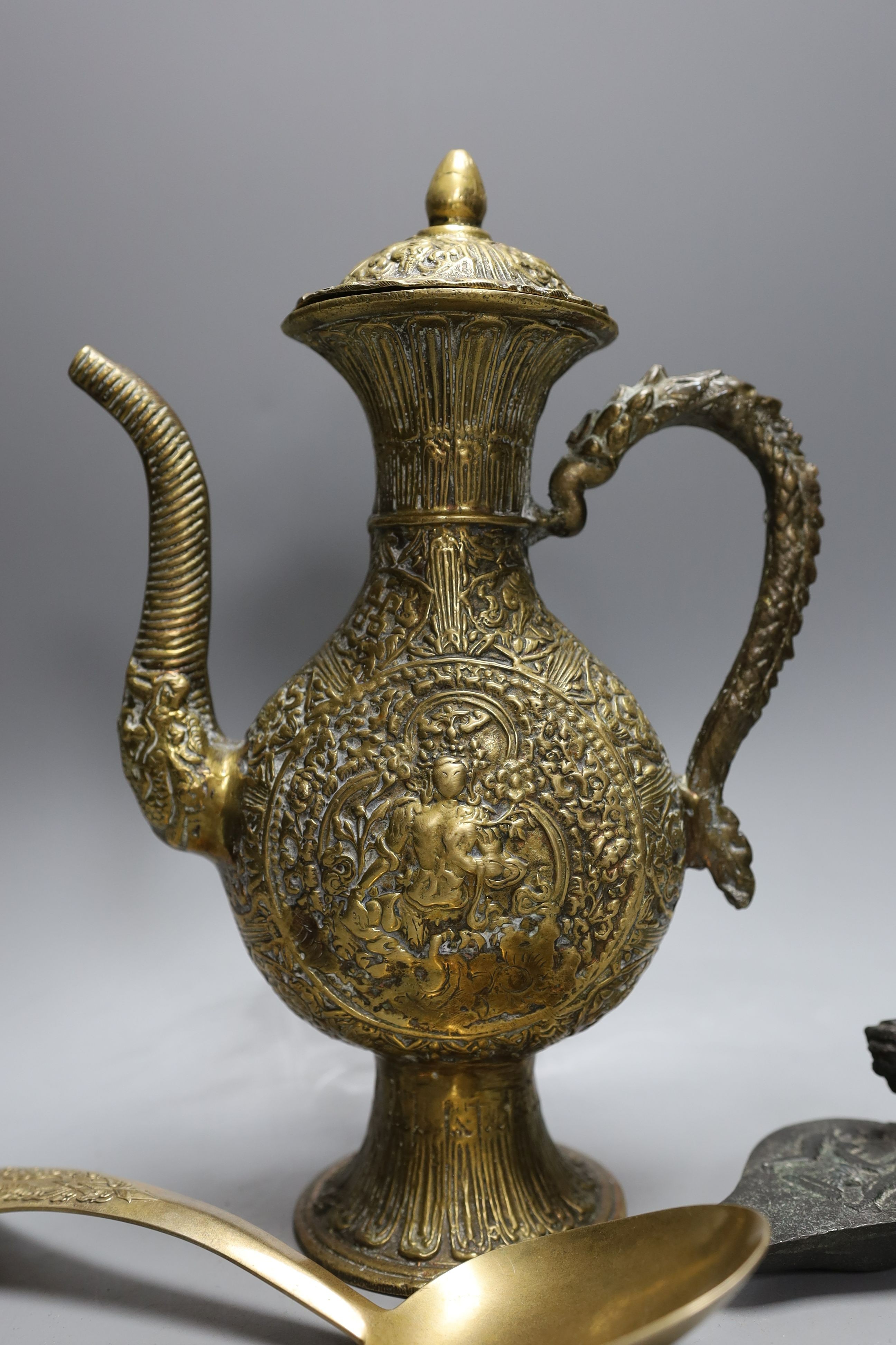 A cast Eastern ewer, 26.5cm tall, together with a miniature cast iron oil lamp and a server spoon (3)